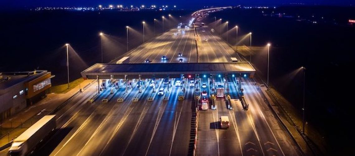 Aerial drone view on motorway with toll collection point at night